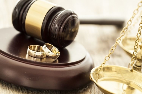 gavel next to wedding rings portraying divorce