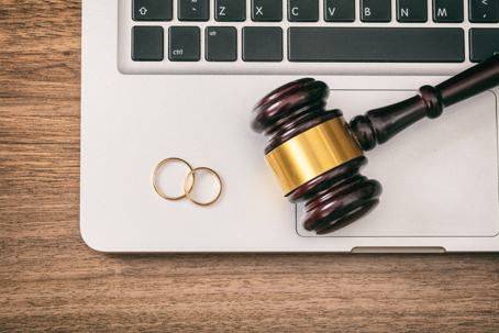 Wedding rings and judge gavel on computer laptop
