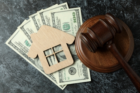 wooden house cutout, money, and a gavel