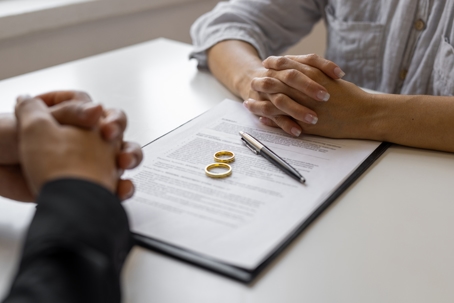 couple facing each other while signing divorce papers