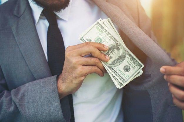 corporate suite white man putting hundred dollar bills in pocket