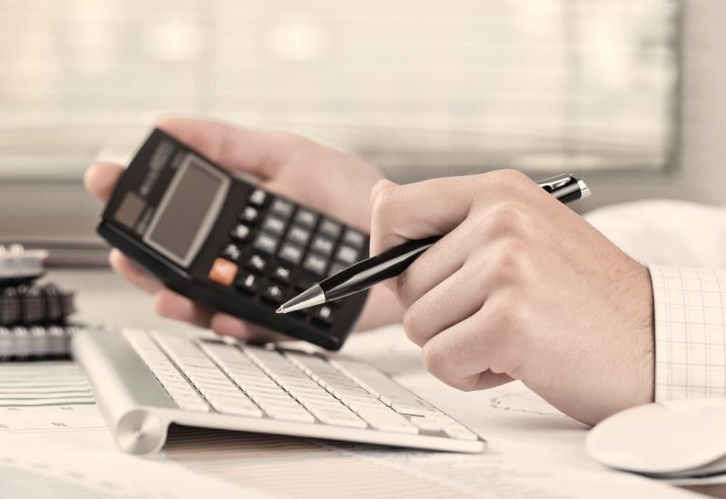 man making calculations using calculator