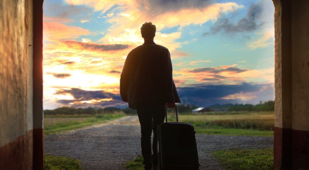 man with suitcase overlooking road