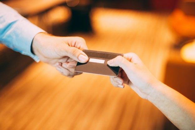two people holding on to a credit card