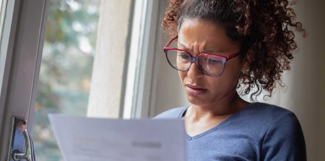 woman looking at paperwork with a worried look on her face