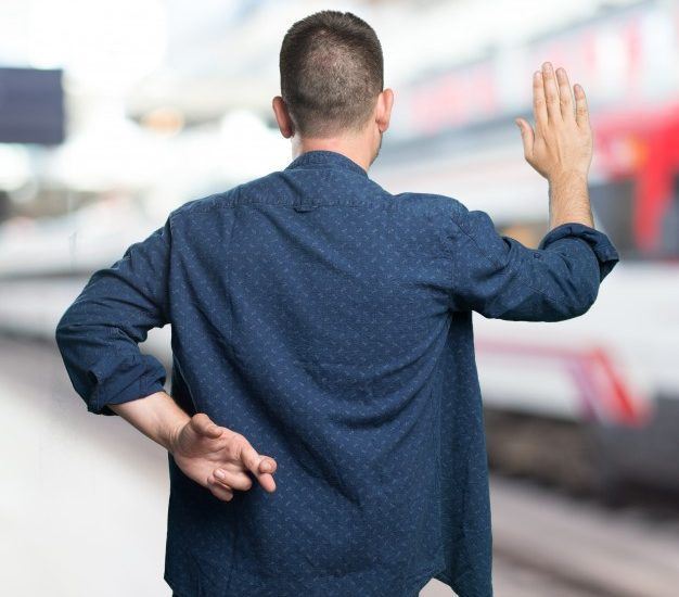 man crossing his fingers behind his back